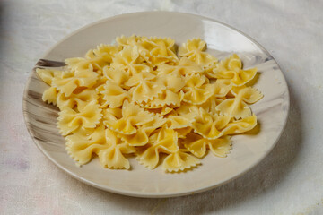 Al dente farfalle pasta on a light plate on the table