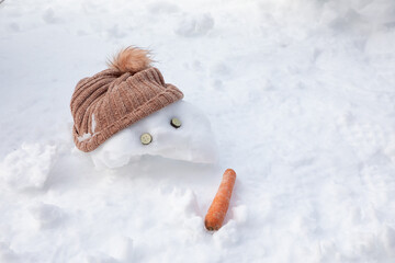 Vista de la cabeza de un muñeco de nieve con gorro y zanahoria durante las navidades de invierno.