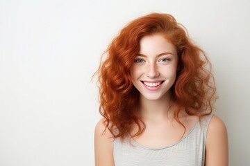 Fototapeta premium Redhaired Beauty Radiating Happiness And Vivacity On The Background Of White Wall