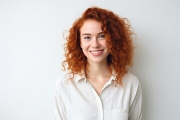 Obraz premium Redhaired Cheerful Young Woman On The Background Of White Wall