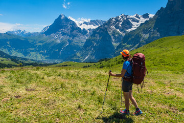 Fototapeta na wymiar Sporty woman hiking in Switzerland alps. Heathy lifestyle, sport, beauty in nature. Grindelwald valley, Swizz