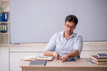 Young male teacher in front of white board