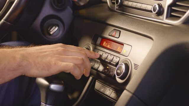 Auto mode. Man's hand using air control panel, pressing button. Turning on the climate control in the car. Adjusting car air conditioning. High quality 4k footage