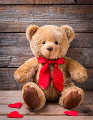 Teddy bear Valentine's Day gift with red tie and hearts on a wooden background. Valentine's Day present