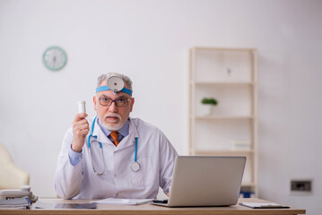 Old male doctor otologist working in the clinic