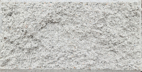 Texture of a large gray street brick block with a chamfer.