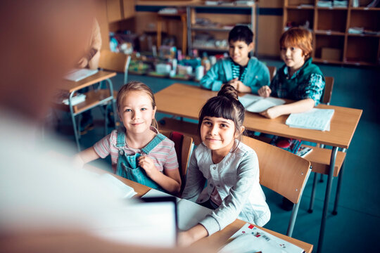 Elementary school kids listening to teacher in classroom - Powered by Adobe