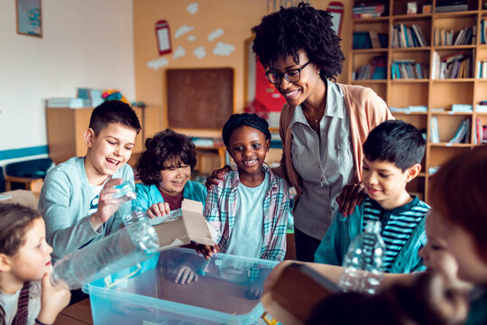 Children learning how to recycle plastic in elementary classroom