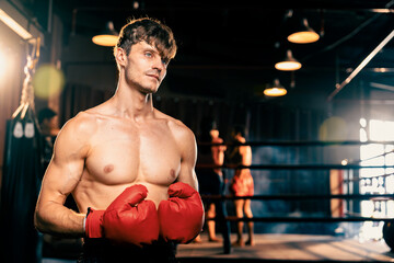 Boxing fighter shirtless posing, caucasian man boxer wearing red glove in defensive guard stance...