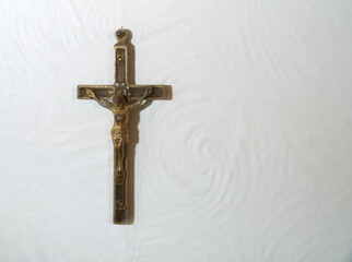 Small brass crucifix on a wall