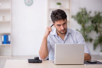 Young male employee working in the office