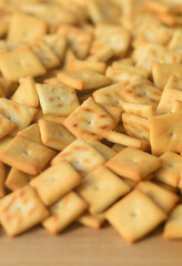 Background texture of small edible squares baked from dough and sprinkled with salt. A lot of salt cracker