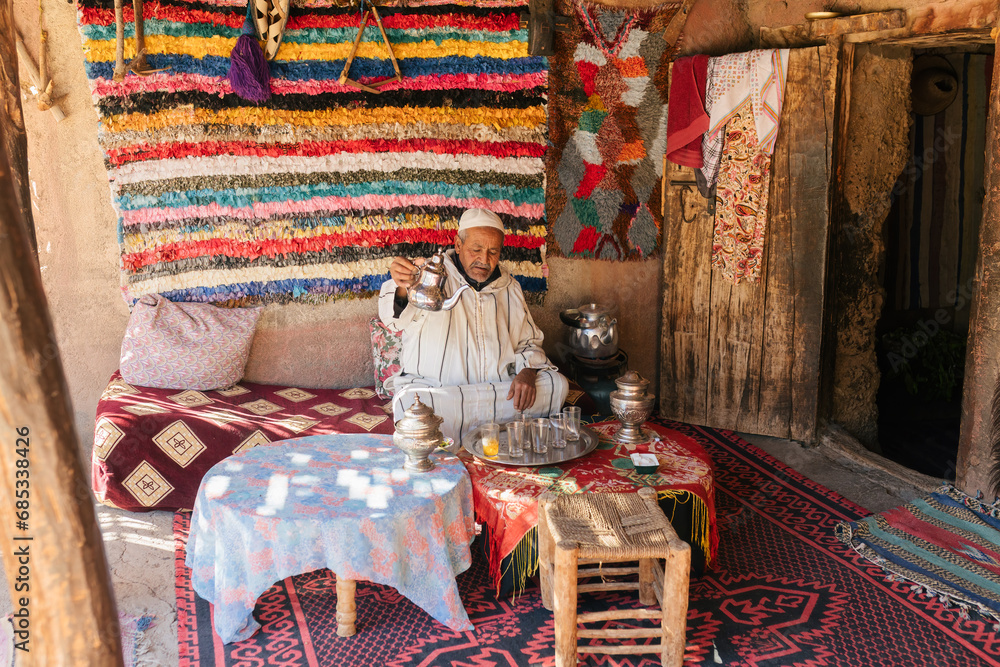 Wall mural man in traditional clothes preparing moroccan tea in cup