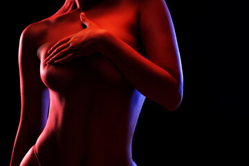 Slim sexy woman in lingerie on a dark background. Her body is illuminated with blue and red lights. - obrazy, fototapety, plakaty