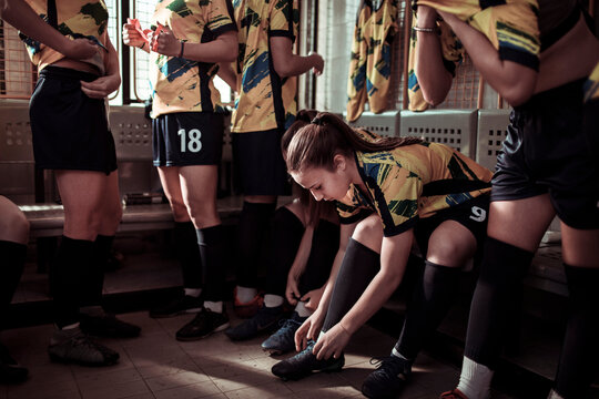 Female soccer players in focused preparation inside the locker room
