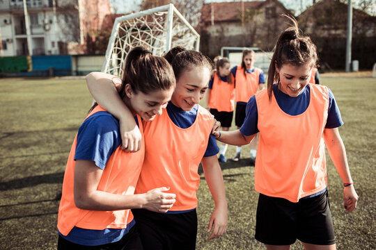 Female football players hugging on the field