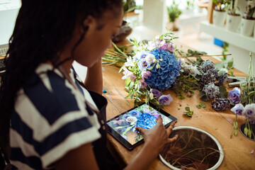 Dedicated florist capturing the elegance of her floral arrangement