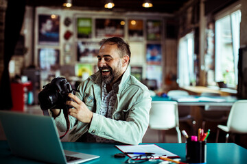 Male photographer going over pictures in startup company office