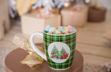 A tasty hot melted chocolate with tiny marshmallows cup in a woman's hand. Winter drinks .cup of aromatic cocoa with marshmallows. Christmas eve,cup of chocolate cozy holiday atmosphere at home.