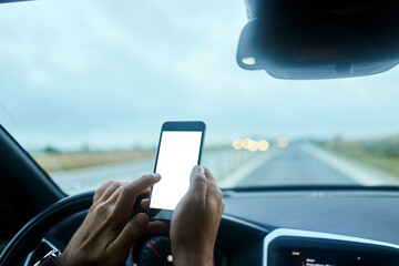 Close up man hands using smartphone at wheel during drive on freeway