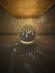 a christmas decoration in the form of an illuminated ball with shooting stars reflected on the wall...