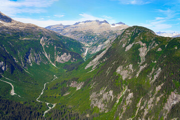 Aerial view of a waterfall flowing in a green valley along the Taku Inlet north of Juneau, Alaska