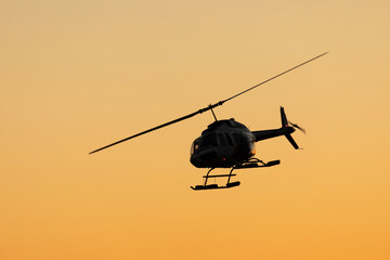 Bell helicopter in midair during sunset