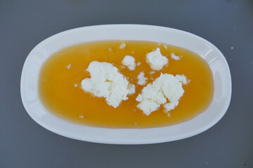 butter cream and honey in a bowl on table .