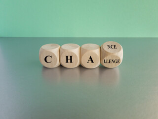 Challenge or chance symbol. Turned a wooden cube and changes the word challenge to chance. Beautiful gray table, blue background, copy space. Business and challenge or chance concept.