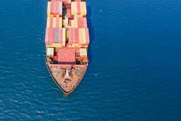 Aerial top down view of a bow from a large container cargo ship traveling with speed in sea