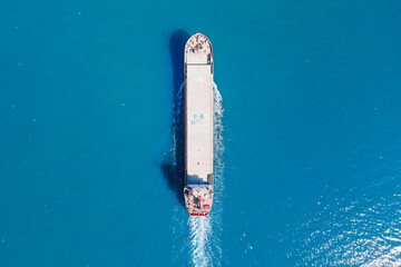 General cargo ship or bulk carrier vessel cruising in sea. top down view