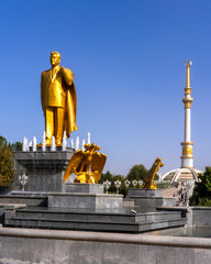 Golden Statue of Turkmenbashi, the First President of Turkmenistan in Ashgabat, with the Independence Monument in the background