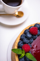 close-up of cheesecake decorated with fresh berries, blueberries and raspberries and mint leaves. confectionery, baking, bright colors