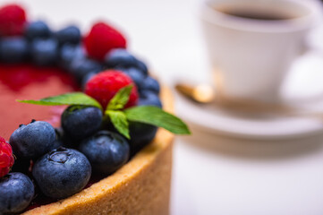 close-up of cheesecake decorated with fresh berries, blueberries and raspberries and mint leaves. confectionery, baking, bright colors