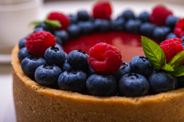 cheese cheesecake close-up view decorated with fresh berries, blueberries and raspberries