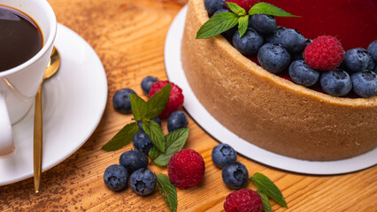 fresh blueberries and raspberries and mint leaves decorated cheesecake close-up. Confectionery, baking, bright colors	
