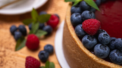 fresh blueberries and raspberries and mint leaves decorated cheesecake close-up. Confectionery, baking, bright colors	
