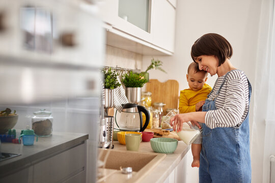 Mother and baby boy in the kitchen preparing breakfast