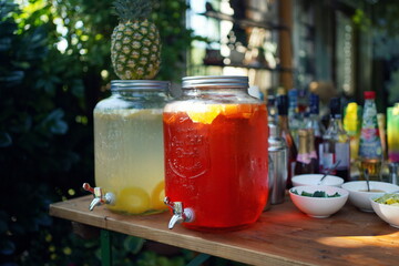 Outdoor bar with two jars with iced fresh cocktails on a garden party