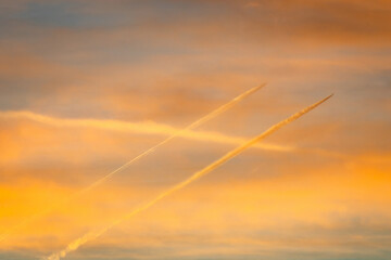 Jet airplanes with contrails on the dramatic morning sky