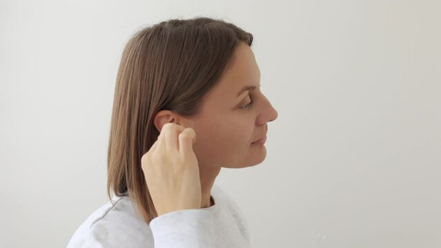 Young woman feels and discomfort while using cotton bud, swab, stick to clean earwax from dirty ear. Earache caused by incorrect bad hygiene, infection, otitis media symptoms, health problems concept