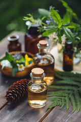 Natural organic essential oil in small glass bottles on wooden background. Homemade production for...