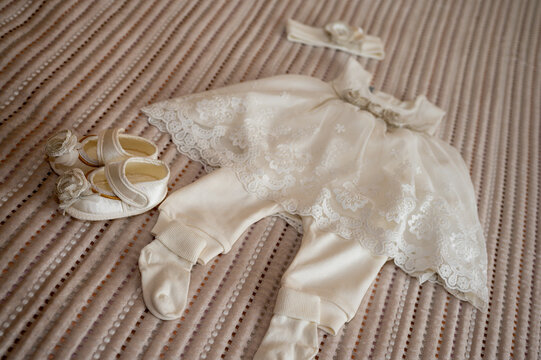 clothes of a small child before baptism on a uniform surface, background. Collecting the child