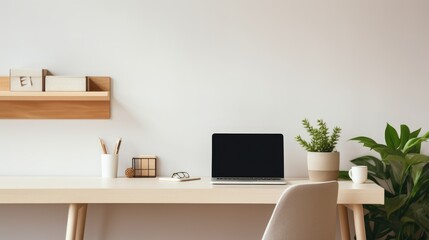  Organized office space with a laptop, stationary, and green plants on a wooden desk.