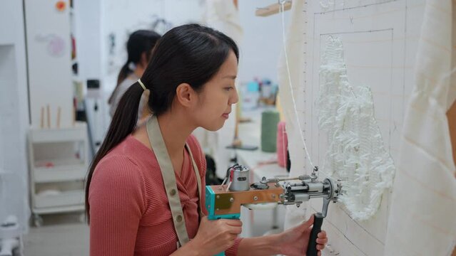 Woman make of tufting carpet at studio