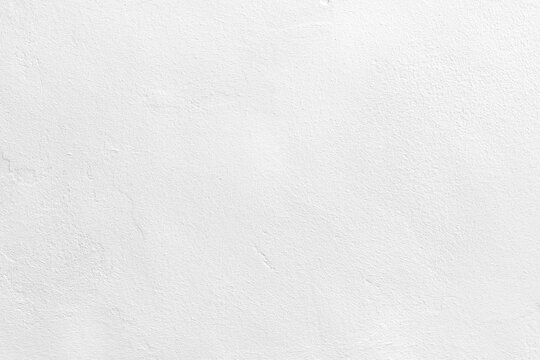 White concrete wall texture background. Uneven render stucco white painted concrete wall texture background. Rough and grunge wall in the sun. 