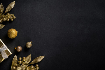 Naklejka premium Christmas gold decorations on black. Flat lay image with copy space.