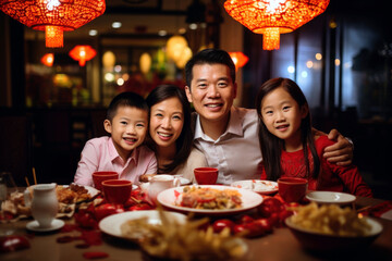 Happy family enjoying Chinese new year dinner together at a table.