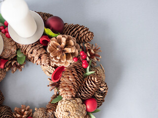 Festive wreath with candles ,cones and decoration of red berries 