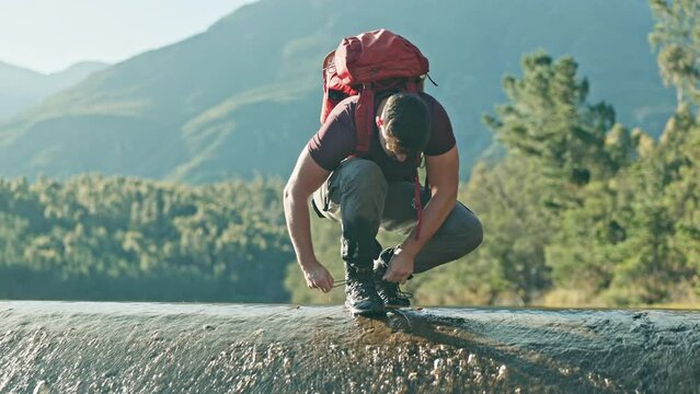 Man, hiking and tie shoelace in nature, river and ready to start walk, journey and trekking on vacation. Hiker, boots and holiday in mountains for fitness, health and forest by water in Argentina